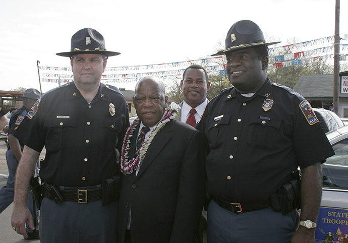 Two Alabama state troopers pose with Congressman John Lewis following the 2009 reenactment of the 1965 voting rights march in Selma, Ala. The officers saw Lewis walking alone and asked if he would pose with them for a photograph. Always gracious, he agreed. File photo by Kathy L. Gilbert, UM News.