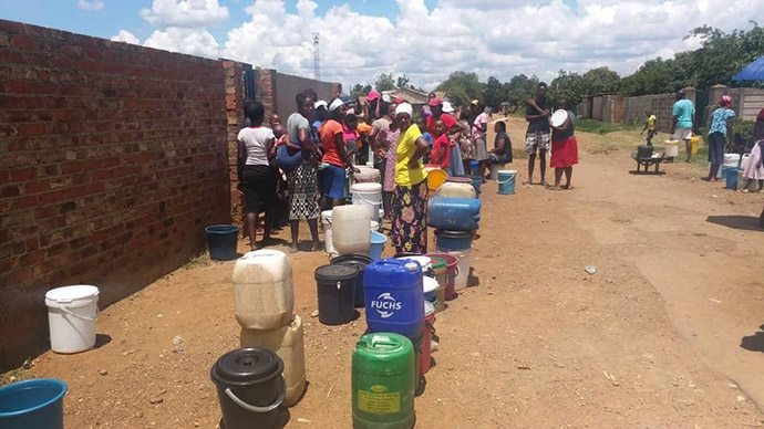 Community members wait in line to fetch water from the bolehole at Highglen United Methodist Church in the suburbs of Harare, Zimbabwe. Photo by Chenayi Kumterera, UM News.