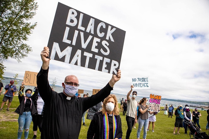 O Rev. Jeremy Wicks (frente) participa de uma demonstração do Black Lives Matter no norte do Michigan. Wicks serviu como capelão da polícia, policial da reserva e organizador da Black Lives Matter. Foto cortesia do Rev. Jeremy Wicks.