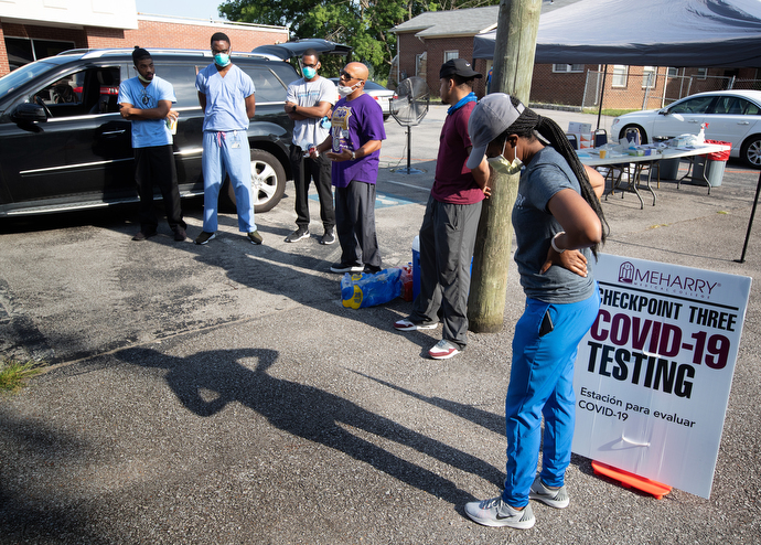 Dr. Millard Collins (center, in purple t-shirt) offers a prayer and last-minute instructions before the opening of a drive-thru testing site for COVID-19 at St. Luke Christian Methodist Episcopal Church in Nashville. Collins is the chair of family medicine at Meharry Medical College. Photo by Mike DuBose, UM News.