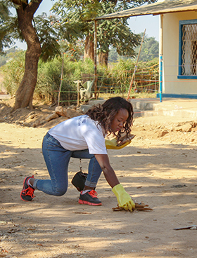 Elalie Tshipeng Kambaj, an AU alumna, picks up debris as part of a community service project in Lubumbashi, Congo. In her role as a health service administrator, she mediates between the South Congo Conference health facilities and the United Methodist Health Board. Photo courtesy of Africa University.