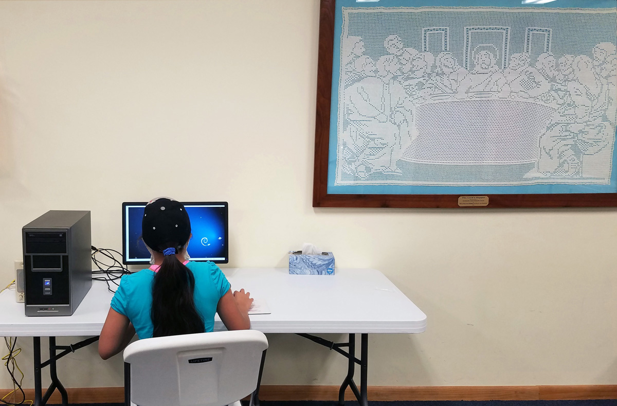 Sarai Moreno, estudiante de séptimo grado, hace la tarea en una computadora en la Iglesia Metodista Unida Robbinsville en Carolina del Norte. La iglesia ha trabajado para brindar acceso al aprendizaje en línea, en un condado rural donde más de la mitad de los hogares no tienen Internet. Las mujeres de la iglesia crearon la Última Cena bordada a la derecha. Foto cortesía del Rev. Eric Reece. Sarai Moreno, estudiante de séptimo grado, hace la tarea en una computadora en la Iglesia Metodista Unida Robbinsville en Carolina del Norte. La iglesia ha trabajado para brindar acceso al aprendizaje en línea, en un condado rural donde más de la mitad de los hogares no tienen Internet. Las mujeres de la iglesia crearon la Última Cena bordada a la derecha. Foto cortesía del Rev. Eric Reece.