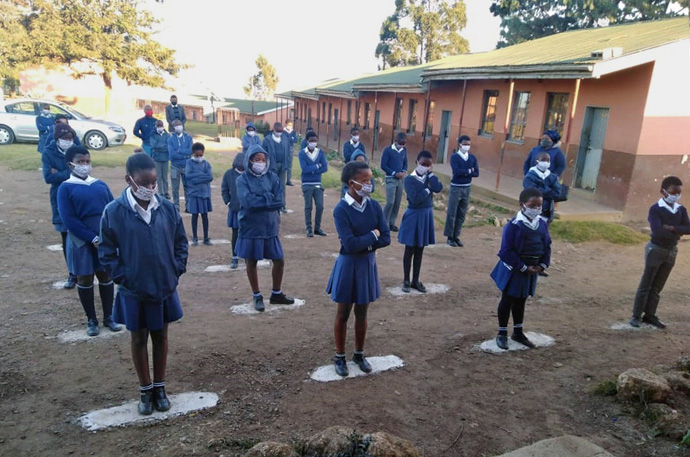 Os alunos usam máscaras e observam o distanciamento social enquanto recebem sua orientação diária antes de começar as aulas na Escola Primária Port Edward em Durban, África do Sul. Foto de Nandipha Mkwalo, Noticias MU.