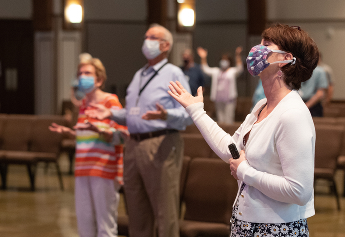 Barbara Layden (front) joins with other parishioners in giving praise during worship at Franklin First United Methodist Church. The church has adopted safety protocols, including no congregational singing, to help prevent the spread of COVID-19. Photo by Mike DuBose, UM News.