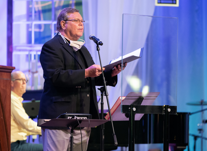 Dave Hintz sings from behind a plexiglass barrier during worship at Franklin First United Methodist Church. The church has adopted safety protocols, including no congregational singing, to help prevent the spread of COVID-19. Hintz is a member of the church’s chancel choir. Photo by Mike DuBose, UM News.