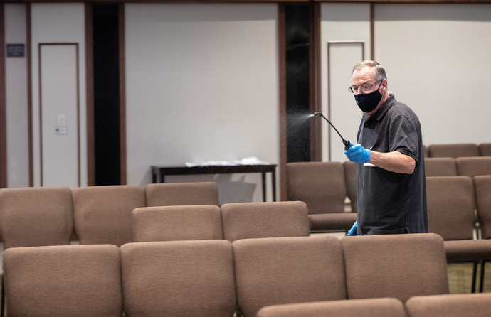 Kevin Gilmartin sprays disinfectant between services at Franklin First United Methodist Church. Photo by Mike DuBose, UM News.