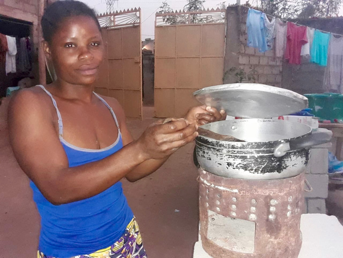 Dona Maria Emília, uma das clientes de Mbala prepara o jantar da família usando um fogão feito artesanal em Luanda, Angola. Foto de Augusto Bento.