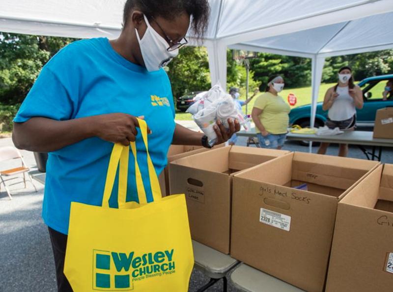 La voluntaria Nicole Lockhart coloca artículos en una bolsa para una familia durante el el día de entrega de morrales de la iglesia Wesley en Bethlehem, realizado el sábado. Foto de April Gamiz, The Morning Call.