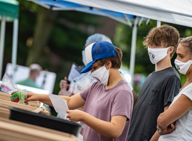 La voluntaria Myranda Block de 16 años, coloca artículos en una bolsa con su hermano Elijah Block de 13 años, y su madre Kindra Block, que también se ofreció como voluntaria durante el día de entrega de morrales de la iglesia Wesley en Bethlehem, realizado el sábado. Foto de April Gamiz, The Morning Call.