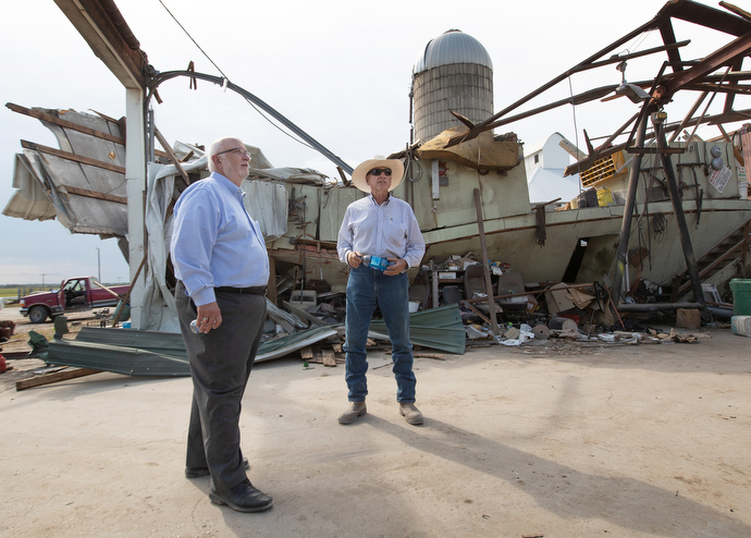 The Rev. Jon Moss (left) visits with Wayne Blackford in what remains of Blackford’s farm maintenance shop near Marion, Iowa, following a derecho windstorm Aug. 10. Moss is pastor of Prairie Chapel United Methodist Church in Marion, where Blackford serves as lay leader. Photo by Mike DuBose, UM News.