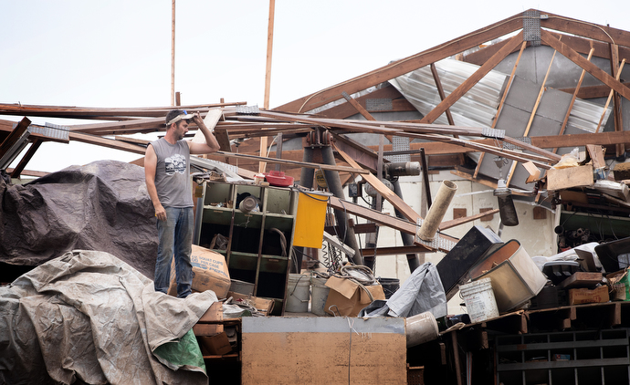 Wyatt Blackford surveys damage caused by a derecho to the maintenance shop at his family’s farm near Marion, Iowa. Photo by Mike DuBose, UM News. 