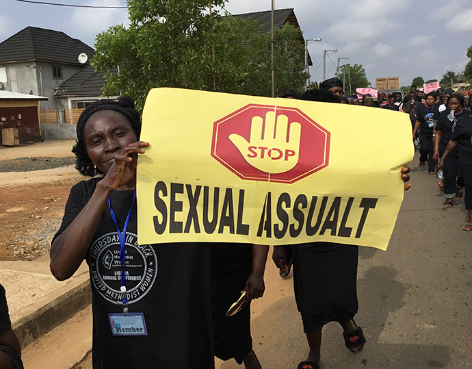 A woman holds a sign calling for an end to sexual violence against women and girls in Liberia. File photo by E Julu Swen, UM News. 