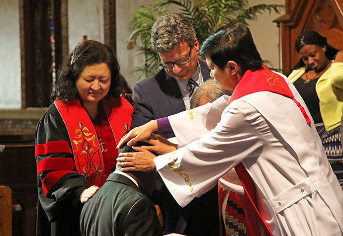 Global Ministries holds the 2017 Global Missionary Commissioning Service in the sanctuary of Grace United Methodist Church in Atlanta. The Rev. Judy Chung, Thomas Kemper, Bishop Hee-Soo Jung and Bishop Pete Torio lay hands on Temba Darlington Nkomozepi, commissioning him into service. File photo by Cynthia Mack, Global Ministries.