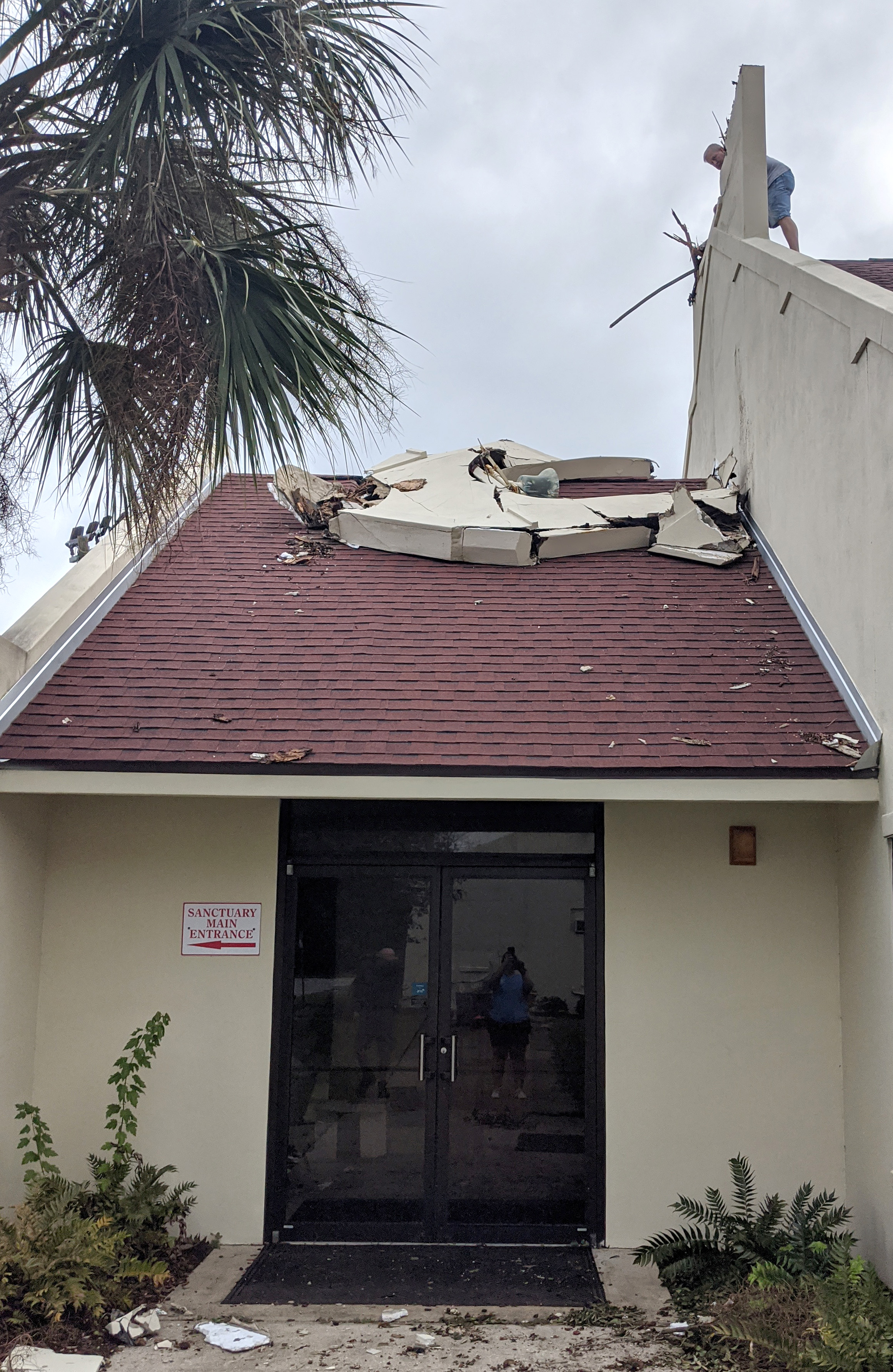 A man on the roof inspects the toppled bell tower at St. Paul United Methodist Church in Gulf Breeze, Fla. Hurricane Sally also caused some water damage to the church.  Photo courtesy of the Rev. Christina Shaver.