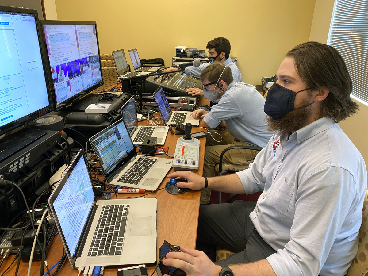 Una vista de la sala de control de video de Ministerio de Medios GNTV durante la reunión anual de la Conferencia Anual Baltimore-Washington, muestra múltiples pantallas de computadora, equipos de audio y técnicos ocupados. Foto cortesía de Ministerio de Medios GNTV.