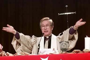 Bishop Hae-Jong Kim blesses the elements of Holy Communion during opening worship at the 2000 United Methodist General Conference in Cleveland. Kim died Nov. 3 at age 85. File photo by Mike DuBose, UM News.