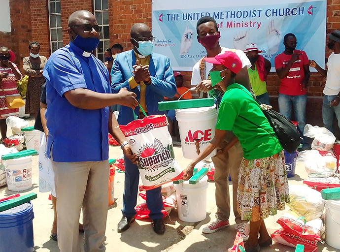 The Rev. Chrispen Musuruware (left) of Hilltop United Methodist Church in Mutare, Zimbabwe, helps distribute food and other supplies to Deaf church members in October, 2020. The distribution was funded by a $5,000 Sheltering in Love grant from the United Methodist Committee on Relief. Photo courtesy of Hilltop United Methodist Church Communications.  
