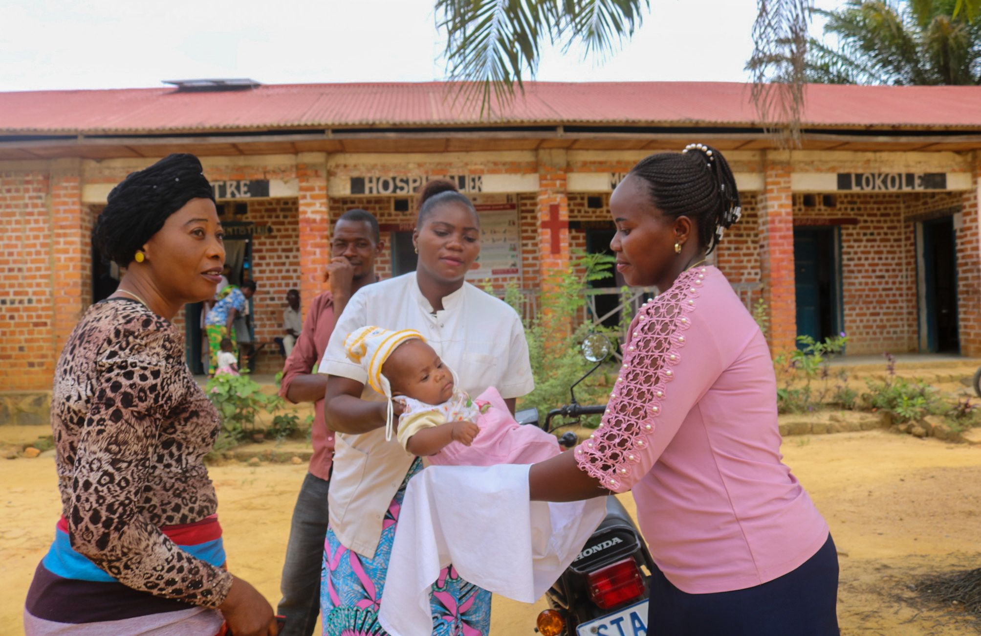 Une infirmière de l’Hôpital Méthodiste Uni de Lokolé à Kindu, en RDC, rend un enfant à sa mère après une séance de vaccination de routine. Les hôpitaux et cliniques de l’Église Méthodiste Unie contribuent à la vaccination de milliers d’enfants chaque année dans le pays. Photo de Chadrack Tambwe Londe, UM News.