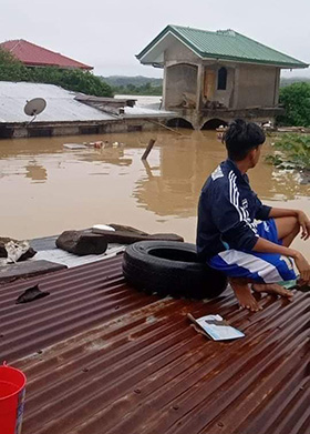 Macky Daguio Mariano, a United Methodist from Afusing United Methodist Church in Alcala, Philippines, waits on his roof to be rescued after Typhoon Vamco (Ulysses) hit the Philippines on Nov. 12. The powerful typhoon caused some of the worst flooding in the region in years. Photo courtesy of Marissa Daguio Caguete.