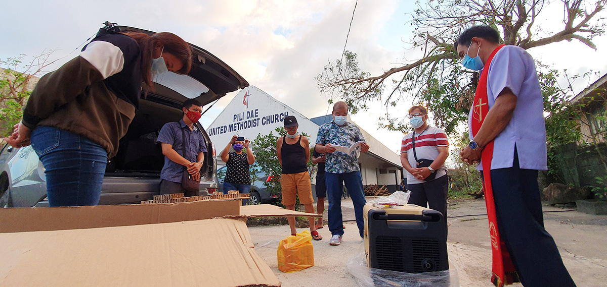 Bishop Rodolfo A. Juan (in red stole) and a team of United Methodists pray over generators for the Bicol Philippines Conference. The generators from United Methodist Communications are being loaned to churches to provide free charging to communities affected by a series of powerful typhoons in the Philippines. Photo by Jerome Mercado. Bishop Rodolfo A. Juan (in red stole) and a team of United Methodists pray over generators for the Bicol Philippines Conference. The generators from United Methodist Communications are being loaned to churches to provide free charging to communities affected by a series of powerful typhoons in the Philippines. Photo by Jerome Mercado.