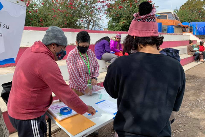 Cindy Andrade Johnson (center), a United Methodist deaconess, helps migrants living in a makeshift camp in Matamoros, Mexico, write letters to U.S. President-elect Joe Biden. Biden promised immigration reform during his presidential campaign. Photo courtesy of Cindy Andrade Johnson.