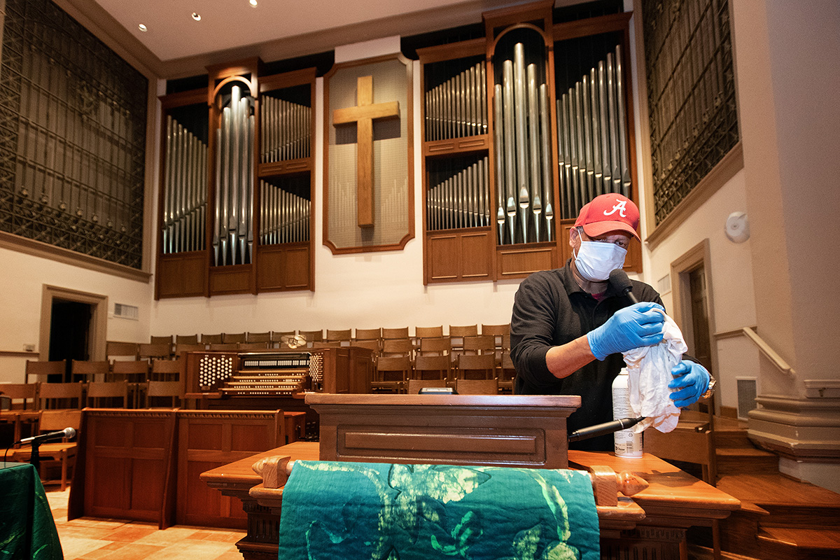 Custodian James Jimmerson disinfects a microphone to prevent any possible spread of the coronavirus at Belmont United Methodist Church in Nashville, Tenn., on Sunday, May 10, following online worship, which is recorded in the sanctuary. As churches considered returning to in-person worship, cleaning measures are one of many factors leaders considered. “I believe my job, my part in this, is to make sure people are safe in here,” Jimmerson said. File photo by Mike DuBose, UM News.