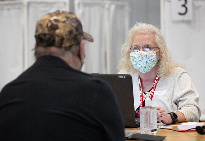 Volunteer Dorothy Fish takes information from a patient who will receive a COVID-19 vaccination at Community United Methodist Church in Vincennes, Ind., where Fish is a member. Photo by Mike DuBose, UM News.