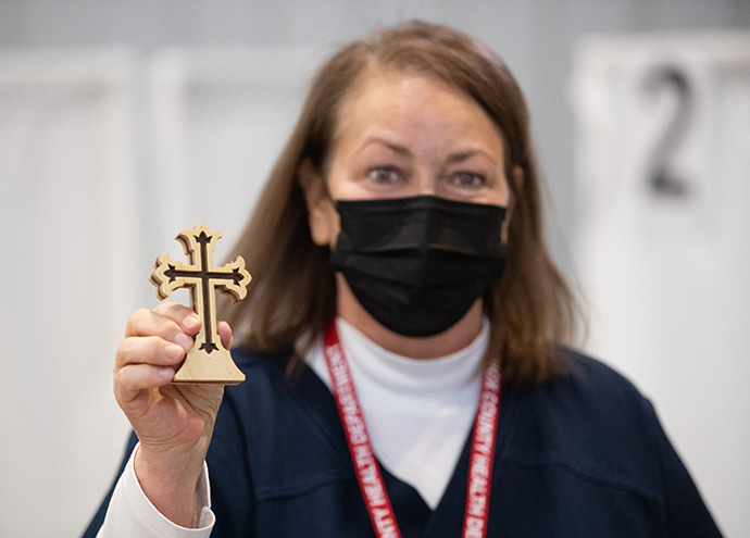 Volunteer Jackie Smith, RN, displays a wooden cross given to her by a grateful patient who had received a COVID-19 vaccination from her at Community United Methodist Church in Vincennes, Ind. Photo by Mike DuBose, UM News.