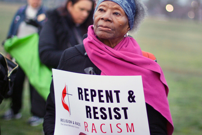 A woman holds a sign during an April 4, 2018, peace and unity rally. The rally followed the United Methodist Commission on Religion and Race’s participation in the United to End Racism Prayer Walk in Washington. File photo courtesy of the Commission on Religion and Race.