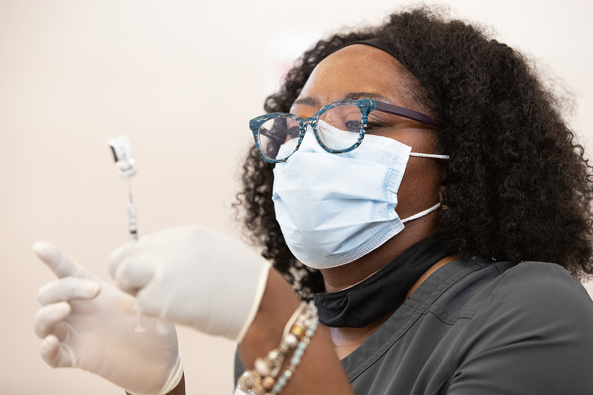 Tia Moore, a nurse practitioner, prepares a dose of COVID-19 vaccine during a vaccination clinic at Meharry Medical College in Nashville, Tenn.