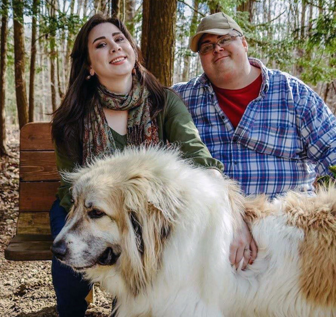 The Rev. Derek Kubilus relaxes with his wife, Maggie, and their dog Beowulf. Kubilus was featured on “60 Minutes” for having launched a podcast taking on the QAnon conspiracy movement. Photo by Reanna Lovsey.