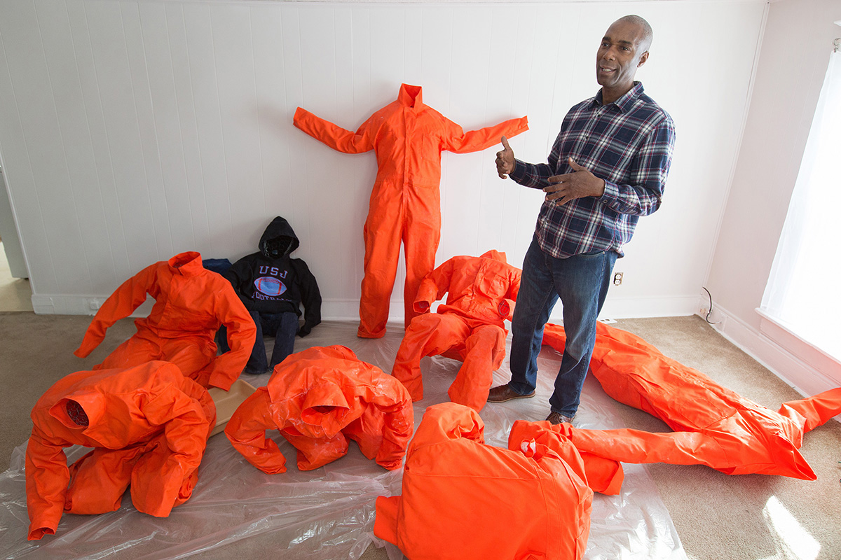 Ndume Olatushani describes his installation artwork featuring human figures in prison-style jumpsuits and hoodies at his home in Nashville, Tenn., in 2017. The work was part of a Stations of the Cross exhibition held in Washington, D.C. Olatushani was freed after serving 27 years in prison, 20 of them on death row. A series of webinars April 26-30 will offer advice to church members on how to support former prison inmates and help them find gainful employment. File photo by Mike DuBose, UM News.