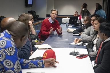 Tim Tanton (center, in red), chief news and information officer for United Methodist Communications, shares updates with African communicators and other UMCom staff during the 2019 General Conference. World Press Freedom Day, observed May 3, commemorates journalists and highlights the difficulties they face while reporting truth. File photo by Kathleen Barry, UM News