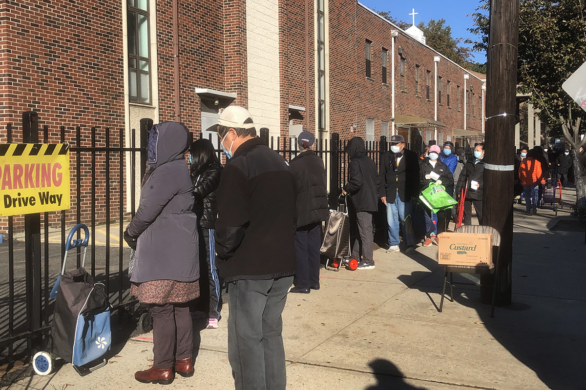 Neighborhood residents wait to receive food during a distribution at First United Methodist Church in Flushing, N.Y. Photo by the Rev. Thomas Kim, UM News.