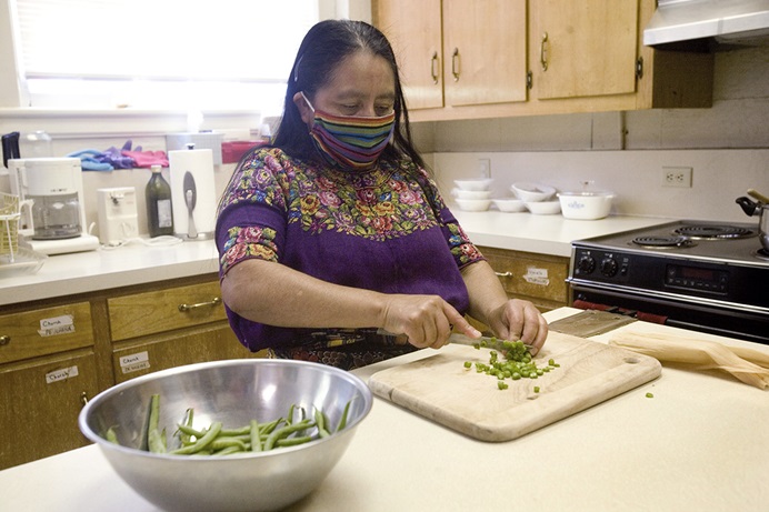 Maria Chavalan Sut prepares a meal for herself in the kitchen at Wesley Memorial United Methodist Church in Charlottesville, Va. After three years of living in sanctuary at the church, Chavalan Sut, who fled Guatemala in 2016, received a Stay of Removal for one year that allows her to move freely until her asylum case is heard. Photo © Richard Lord.