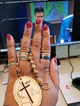 King prays with United Methodist-made prayer beads as she watches a 2019 special General Conference session online. Photo courtesy of King.