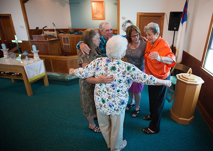 Church members share a group hug with pastor Laura Vincent (second from right) following worship at Oakton United Methodist Church near Clinton, Ky., in 2015. Prior to the COVID-19 pandemic the small congregation shared a hug with their pastor each week and are looking forward to being able to revive the tradition. File photo by Mike DuBose, UM News.