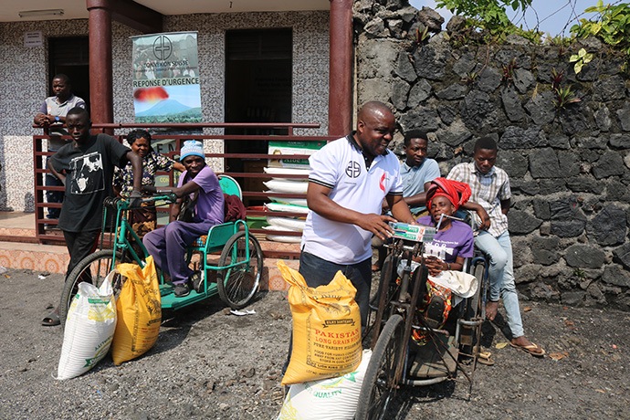 Rebeca Lamirwa, seated on her hand-cranked tricycle, receives relief supplies reserved for people with handicapping conditions from the United Methodist Committee on Relief and Connexio Switzerland in Goma, Congo. Photo by Philippe Kituka Lolonga, UM News.