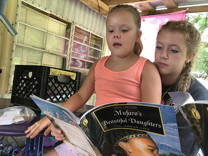 Nora Hammer (right) from St. Mary’s Catholic Church in Oregon, Ill., reads with Lillian Clark, 8, at a volunteer worksite in Gruetli-Laager, Tenn. Photo by the Rev. Thomas Kim, UM News.