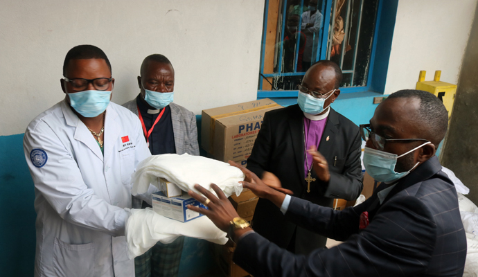 Bishop Gabriel Yemba Unda (center, in purple clerical shirt) delivers a batch of drugs to the Majengo United Methodist Health Center in Goma, Congo. A $10,000 grant from United Methodist Global Ministries’ Global Health unit provided bed nets, medicine and medical supplies, personal protective equipment and hygiene kits. Photo by Philippe Kituka Lolonga, UM News. 