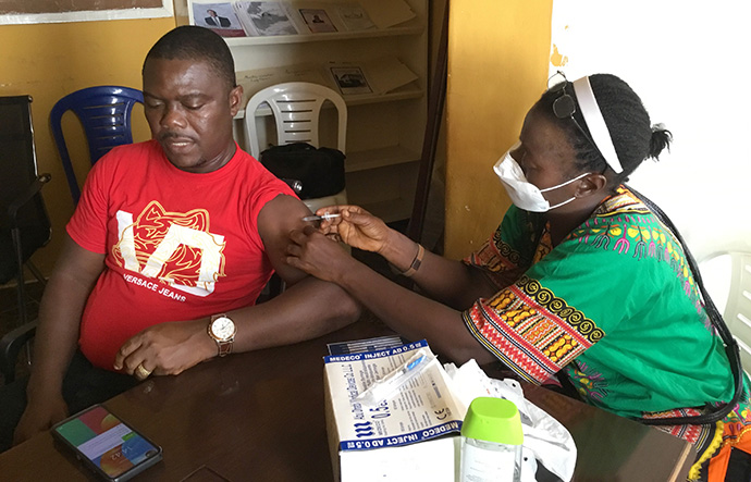 Philip M. Kollie receives a COVID-19 vaccine from a mobile clinic at S. T. Nagbe United Methodist Church in Monrovia, Liberia. Photo by E Julu Swen, UM News.