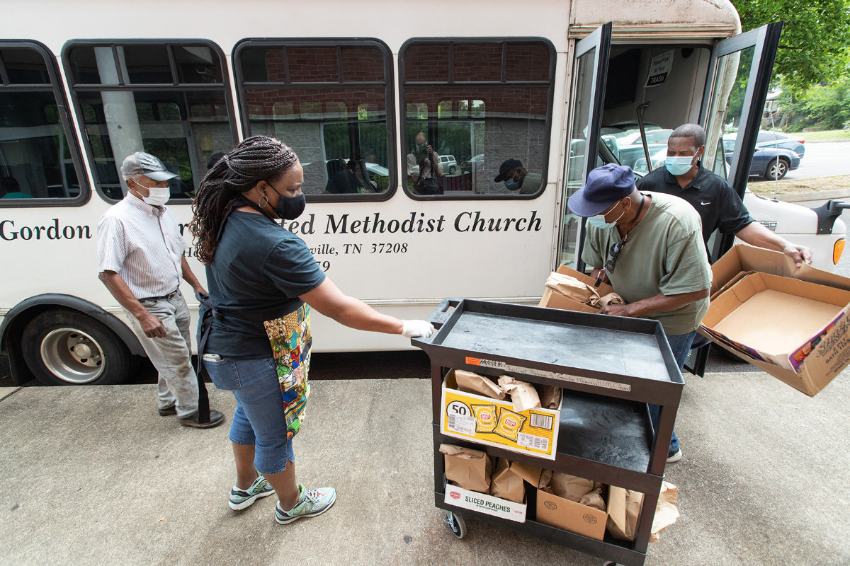 The Rev. Paula Smith (second from left) steadies a cart while volunteers Tim Morgan (in green T-shirt) and Richard Wilson load box lunches for distribution at Gordon Memorial United Methodist Church in Nashville, Tenn. A new study by Gammon Theological Seminary explores the pandemic’s impact on Black United Methodist churches and leaders. File photo by Mike DuBose, UM News.