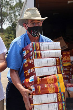 Texas Conference Bishop Scott Jones carries boxes of Cheerios, among two truckloads of supplies the conference brought to Broadmoor United Methodist Church in Baton Rouge, La., on Sept. 6, as part of Hurricane Ida relief. Photo courtesy of the Texas Conference.