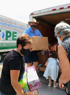 Louisiana Conference Bishop Cynthia Fierro Harvey (at left) and Texas Conference Bishop Scott Jones (center) help unload supplies at Broadmoor United Methodist Church in Baton Rouge, La. The Texas Conference brought two trucks full of nonperishable foods and other targeted supplies to a staging area at the church. Photo courtesy of the Texas Conference.