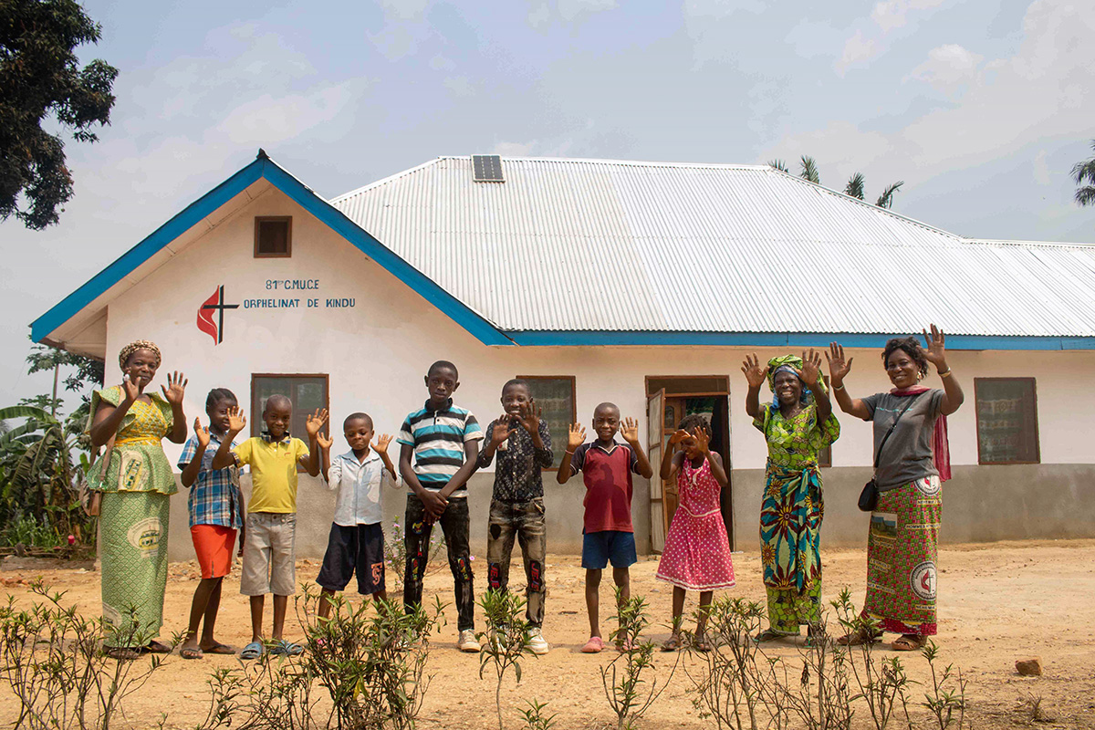 Children and staff wave from in front of the new United Methodist orphanage in Kindu, Congo. The facility, constructed from sustainable materials, was built with funding from the United Methodist Board of Global Ministries. Photo by Chadrack Tambwe Londe, UM News.