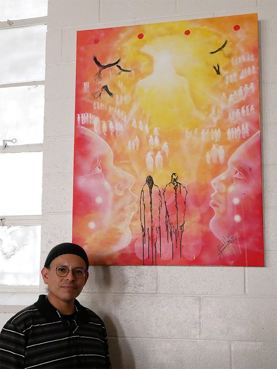 El artista Damon Neal posa junto a otra de sus obras que se exhiben en la IMU Indígena de Dallas, estado de Tejas. Foto cortesía de la Conferencia Anual del Norte de Tejas.