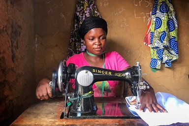 Henriette Kibibi, 22 ans, coud des uniformes dans son atelier situé dans un Quartier périphérique de Kindu, au Congo. Kibibi, mère de deux enfants, a reçu une formation professionnelle au Centre Mama Lynn de Kindu qui l'aide à subvenir aux besoins de sa famille. Photo de Chadrack Tambwe Londe, UM News. Henriette Kibibi, 22 ans, coud des uniformes dans son atelier situé dans un Quartier périphérique de Kindu, au Congo. Kibibi, mère de deux enfants, a reçu une formation professionnelle au Centre Mama Lynn de Kindu qui l'aide à subvenir aux besoins de sa famille. Photo de Chadrack Tambwe Londe, UM News.