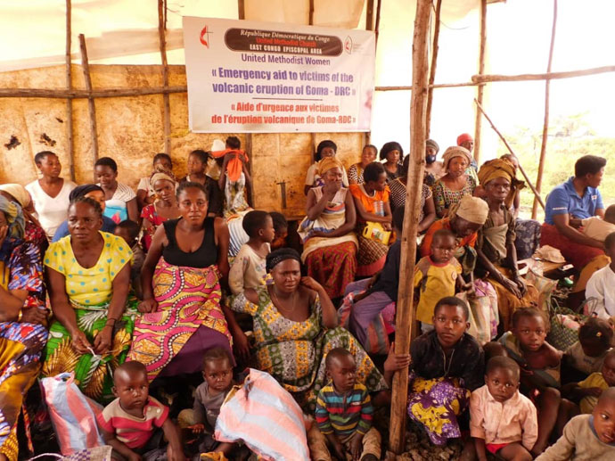 Des femmes veuves attendent la distribution de la nourriture au camp des déplacés de Bojuvu 1 dans le territoire de Nyirango au Sud Kivu. De nombreuses femmes et des veuves souffrent pendant cette période après que leurs champs aient été calcinés par le feu du volcan. L’Eglise a apporté une assistance aux femmes veuves et orphelins. Photo par Jolie Mulebinge, UM News.