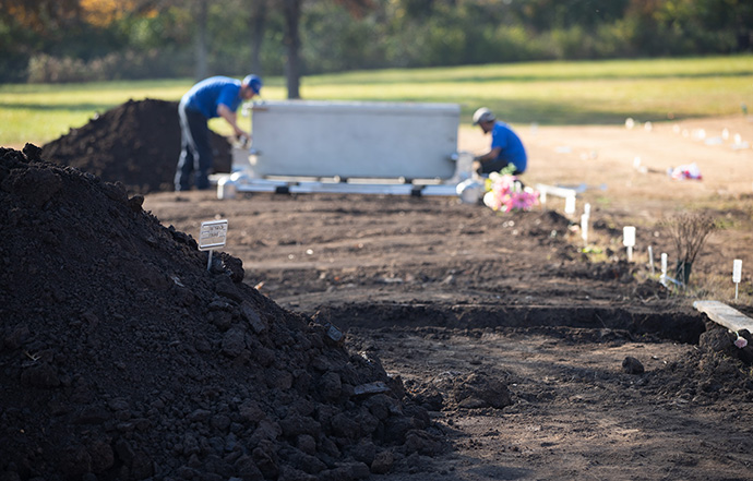 Workers from Wilbert Funeral Services prepare one of five burial vaults for interment at Hills of Calvary Memorial Park in Nashville, Tenn., prior to services for Nashville residents who died and weren’t claimed by anyone. Photo by Mike DuBose, UM News. 