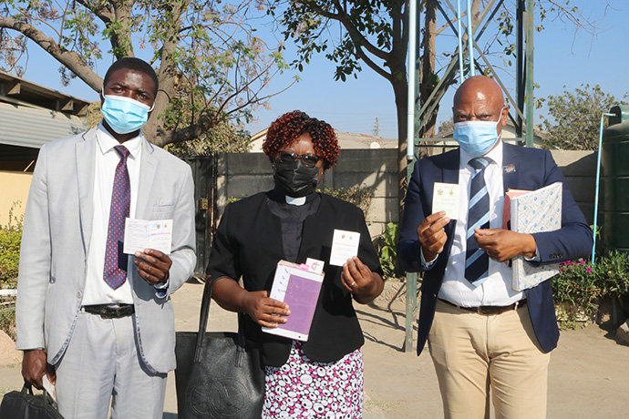 Leaders from Seke South United Methodist Church near Harare, Zimbabwe, display their COVID-19 vaccination cards. The United Methodist Church is partnering with governments to promote vaccinations. In Zimbabwe, three United Methodist hospitals and 12 clinics are vaccination sites. From left are: Pastor Lameck Makuza, the Rev. Juliet Thondhlana and lay leader Michael Dengwani. Photo by Eveline Chikwanah, UM News.